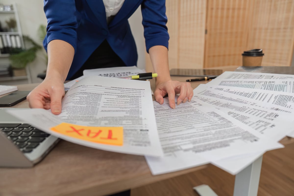 A tax professional reviewing and preparing client tax documents in a contemporary office